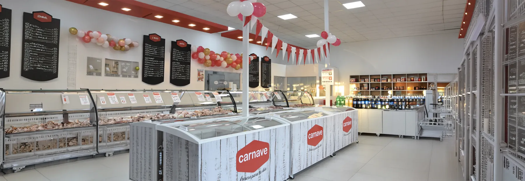 Interior de una tienda Carnave: heladeras, freezers con la marca y las pizarras de precios